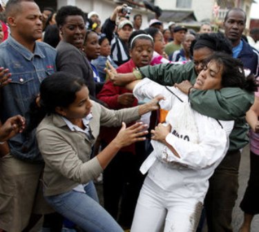 Policía política cubana reprime a la opositora Sara Martha Fonseca (de blanco).