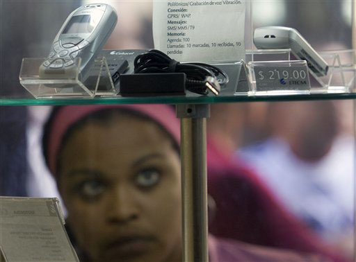Una mujer contempla celulares en las vidrieras en Cuba