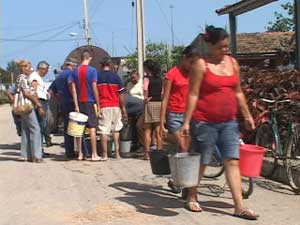 Residentes de Niquero, en el este de Cuba, cargan agua distribuida por las autoridades locales para frenar el brote de cólera. Foto: CaféFuerte
