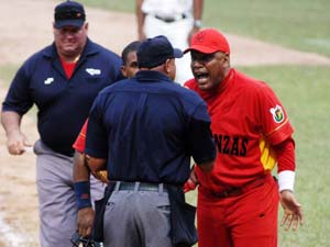 Victor Mesa (de rojo) discute con los árbitros durante la pasada Serie Nacionale de béisbol en Cuba