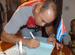 Michel Enríquez firma en Nueva Gerona el libro de condolencias por la muerte del pastor Lucius Walker en el 2010. Ahora firmó con los Piratas de Campeche en México.